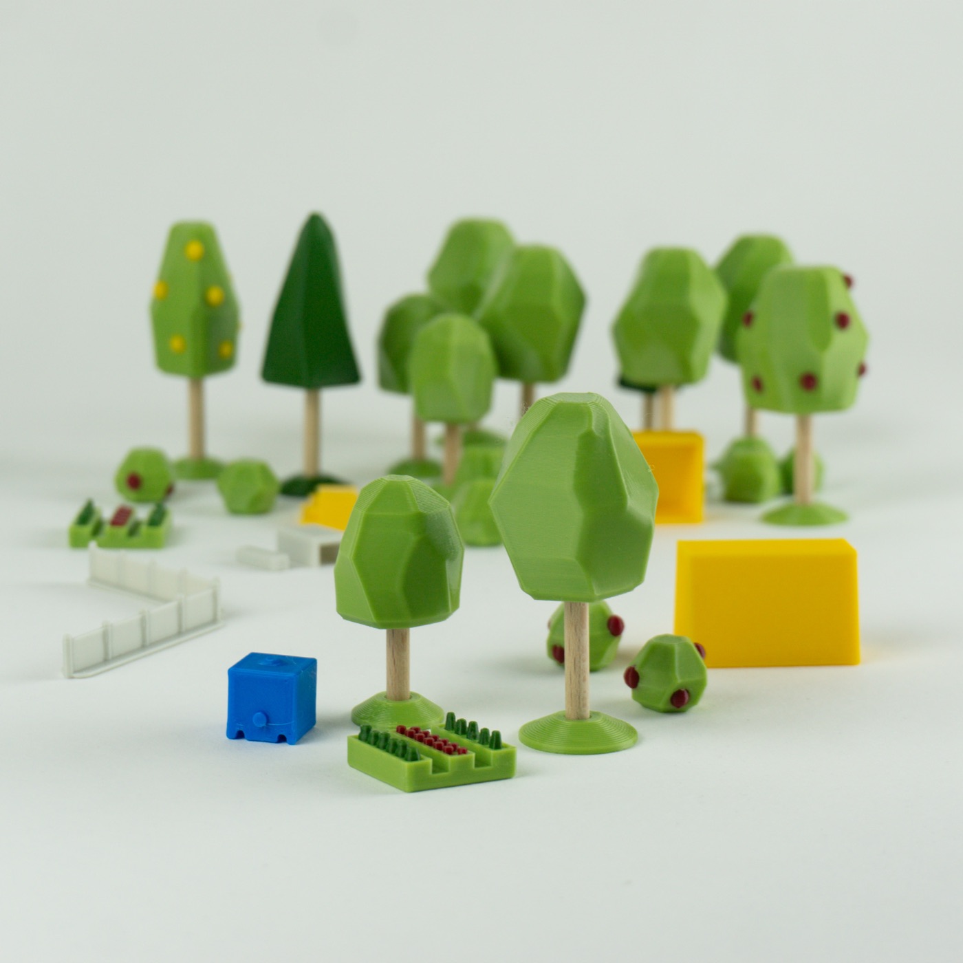 Les pièces du kit Repenser la cour d'école : arbres sur socle, jeux, bancs.