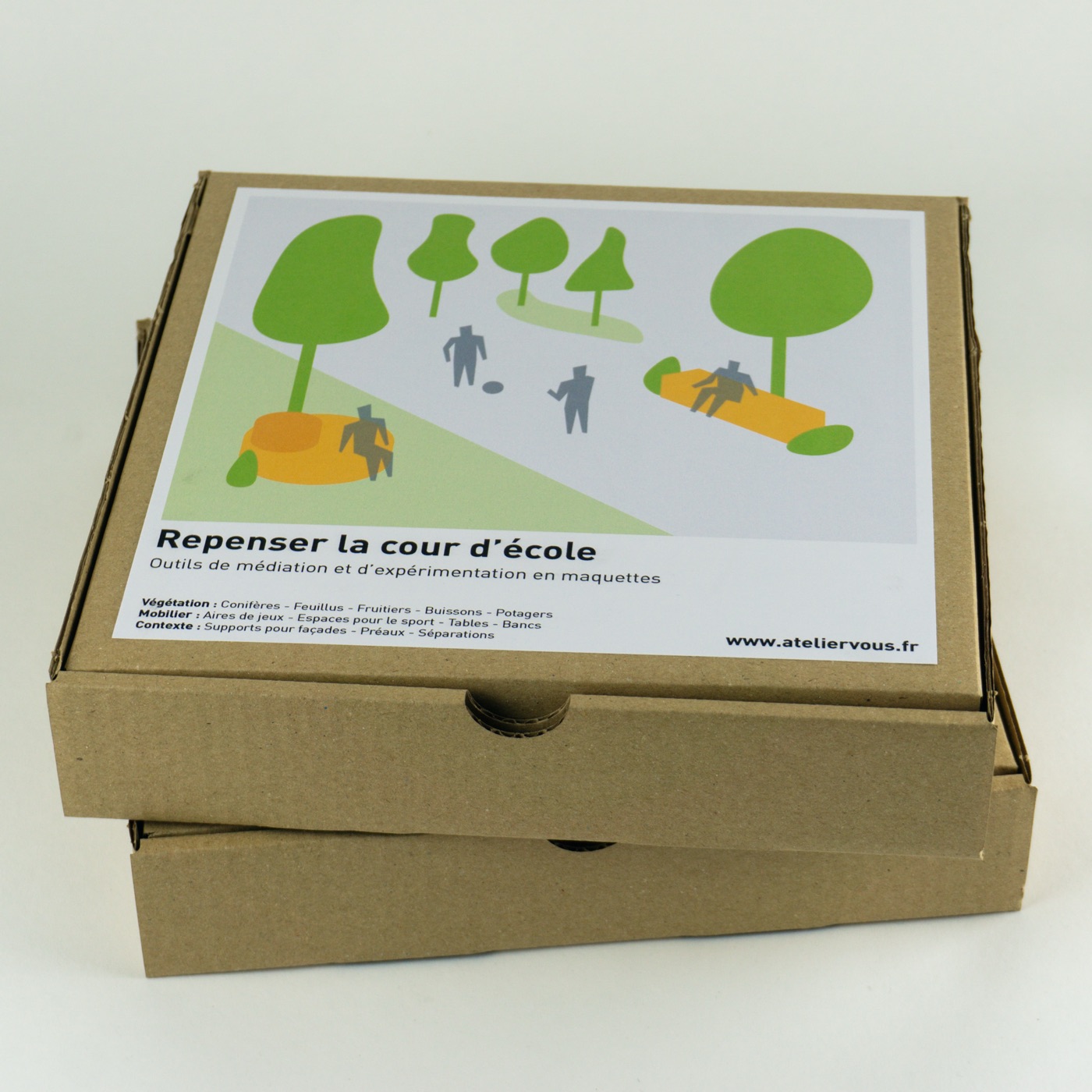 Deux boîtes du kit empilées, couvercle illustré « Repenser la cour d'école ».